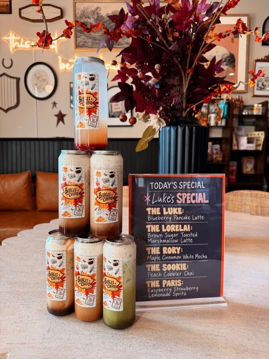 Themed drinks displayed beside a Luke’s Special menu board and autumn foliage inside the cafe