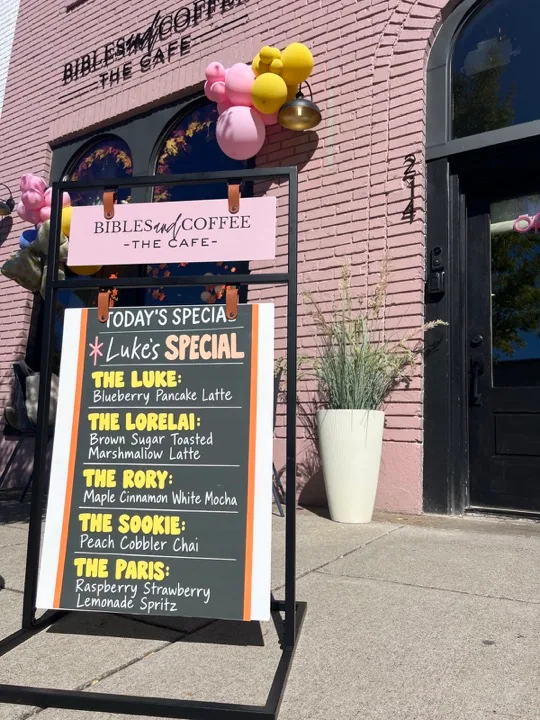 A sidewalk menu outside Bibles and Coffee featuring The Luke, The Lorelai, The Rory, The Sookie and The Paris drinks